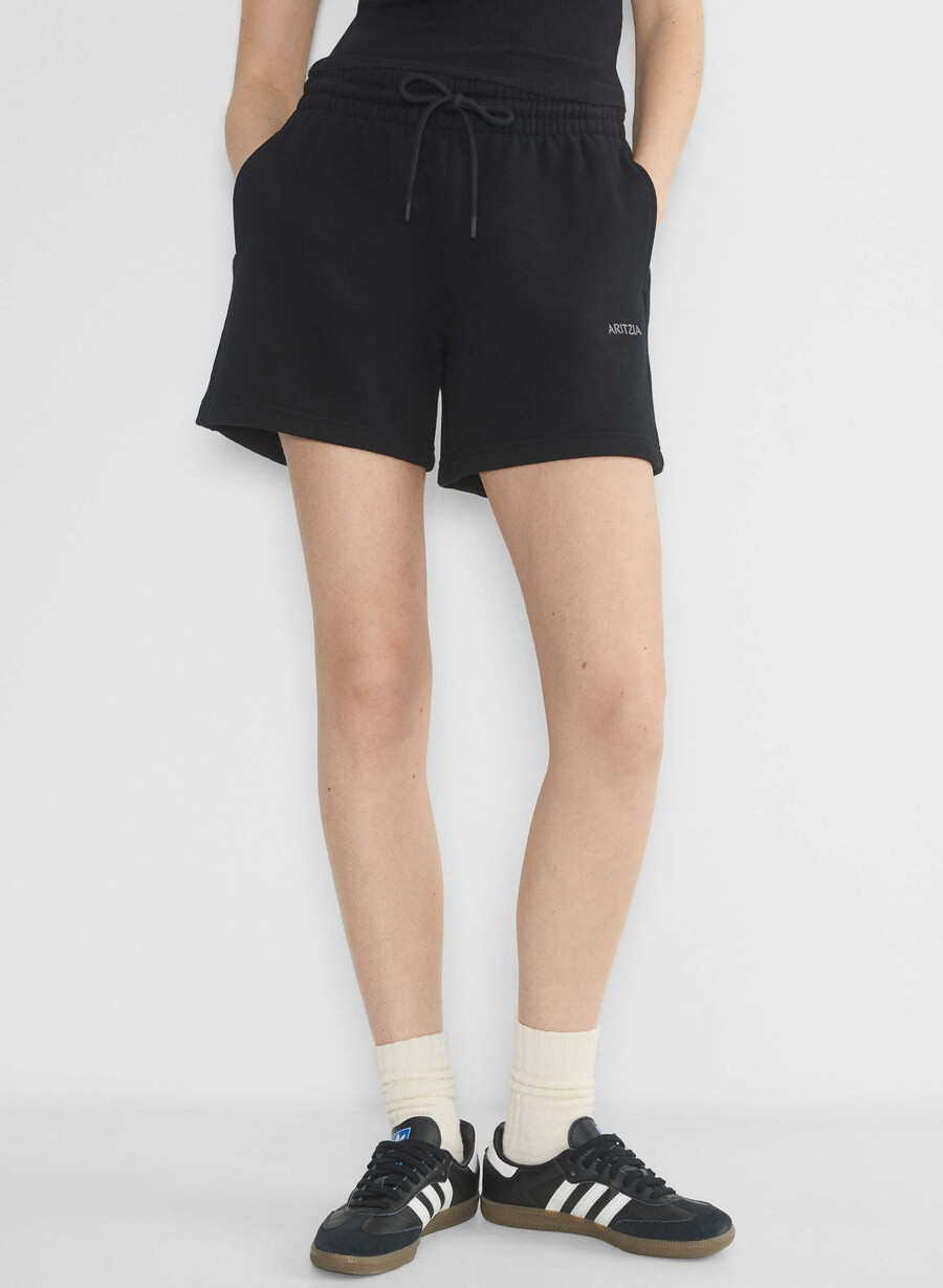 schwarze kuschelige boyfriend-shorts aus sweatfleece mittellang bis zum oberschenkel.