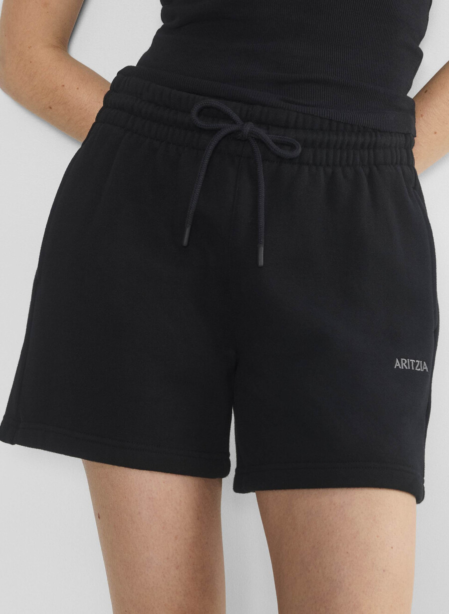 schwarze kuschelige boyfriend-shorts aus sweatfleece mittellang bis zum oberschenkel.