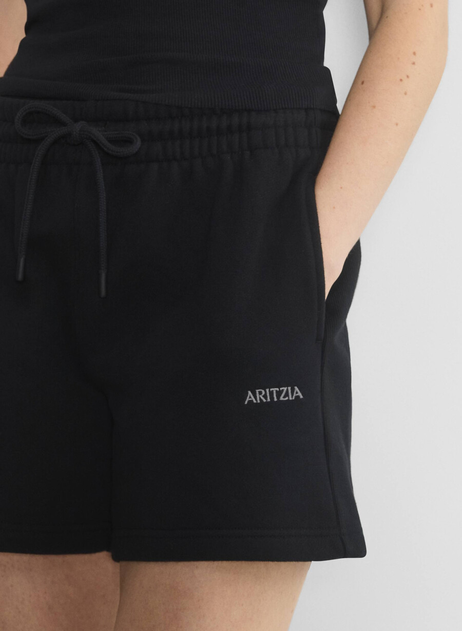 schwarze kuschelige boyfriend-shorts aus sweatfleece mittellang bis zum oberschenkel.