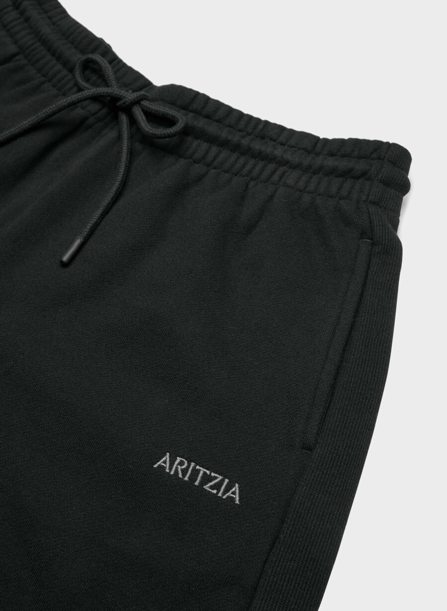 schwarze kuschelige boyfriend-shorts aus sweatfleece mittellang bis zum oberschenkel.